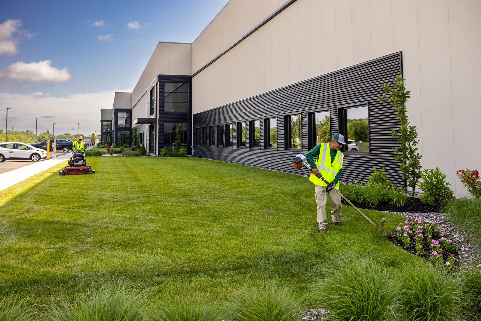 Landscaping crew mowing and trimming the grounds of a commercial building in Bucks County, PA