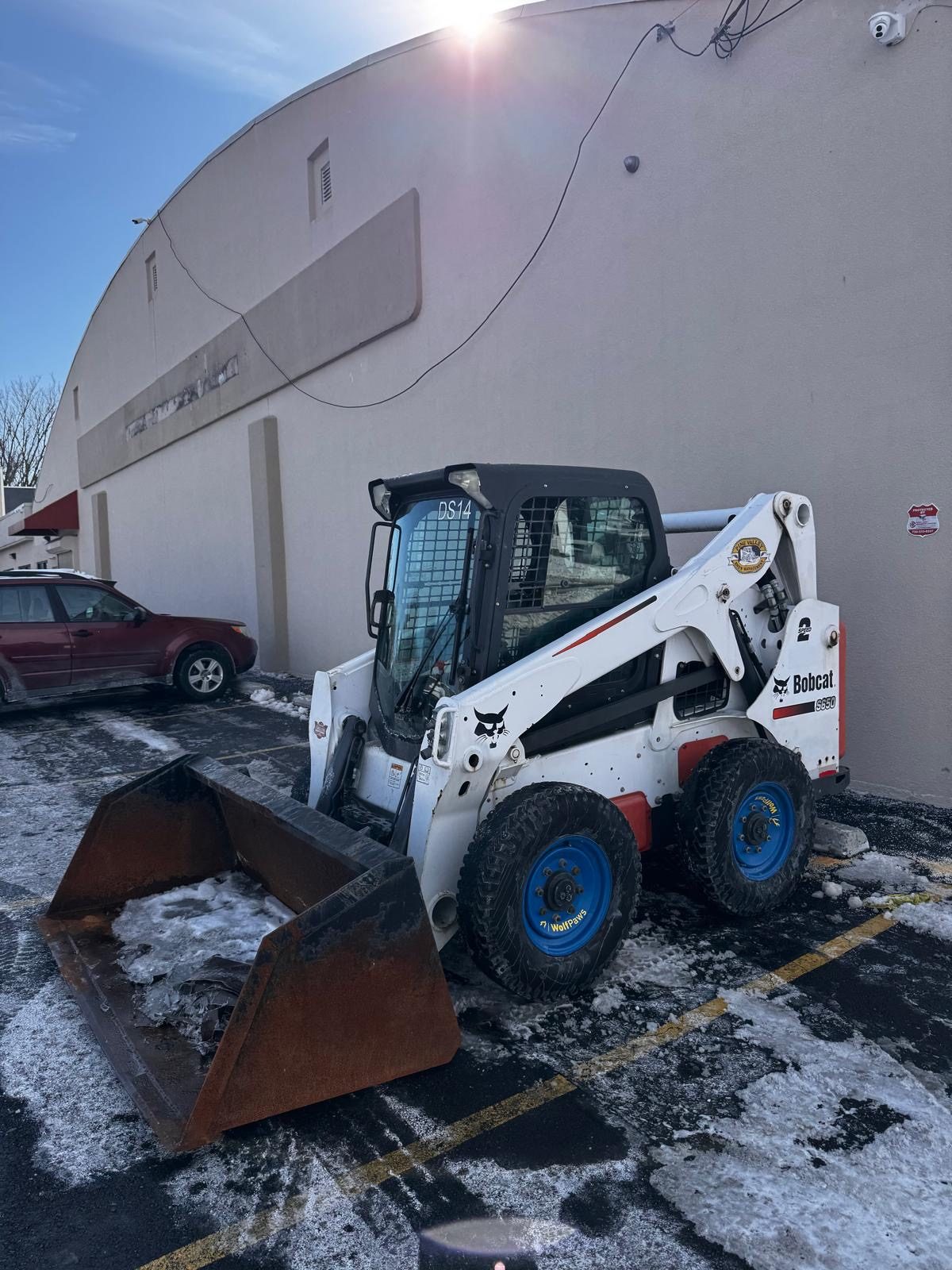Devlin Services skid steer clearing snow at a commercial property in Bensalem, PA